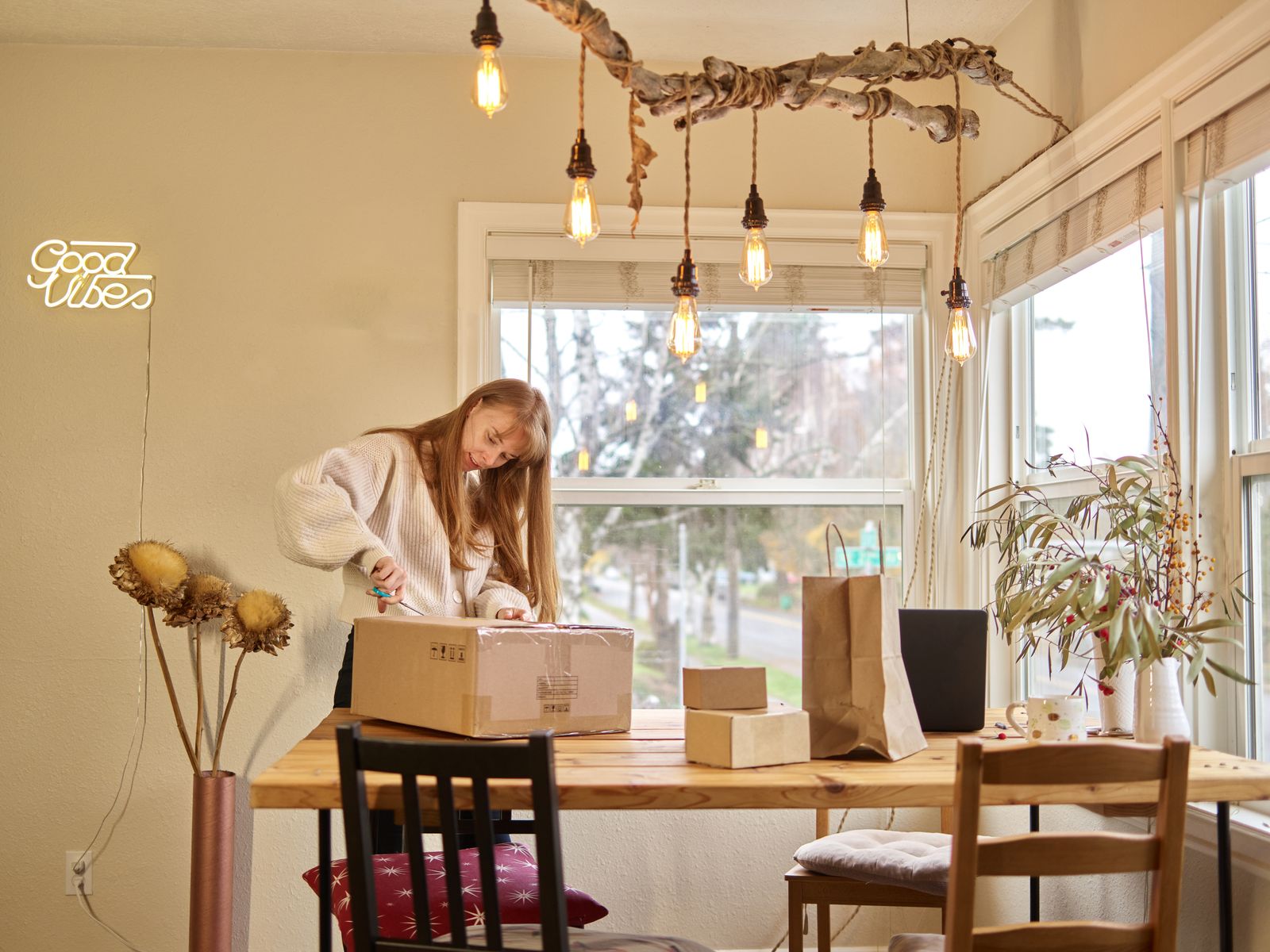 A woman carefully opening a delivered cardboard parcel